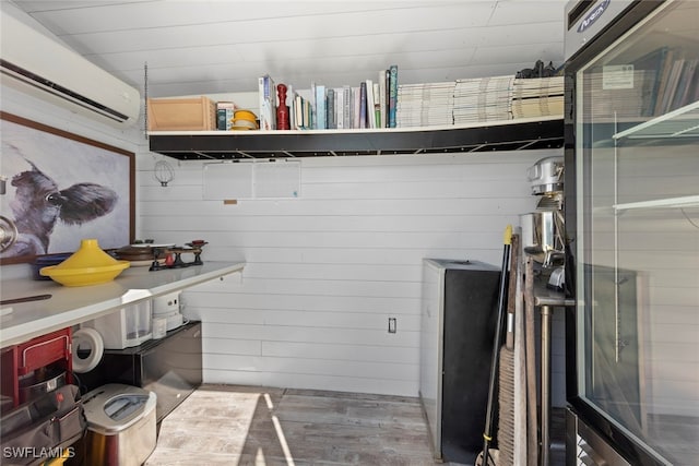 interior space with a wall unit AC, hardwood / wood-style flooring, and wood walls