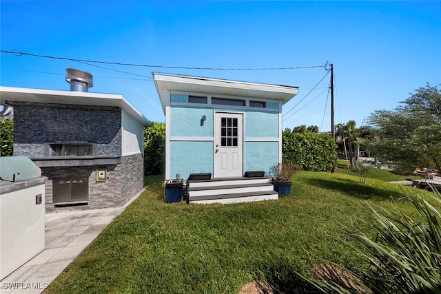 view of outbuilding with a lawn and exterior kitchen