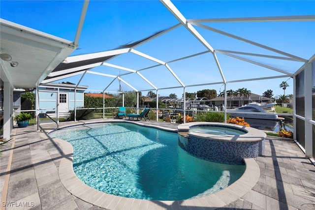 view of pool with an in ground hot tub, a patio area, and a lanai