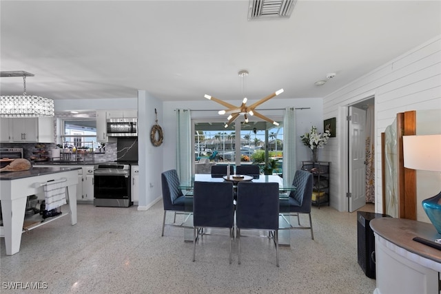 dining space featuring a wealth of natural light and wood walls