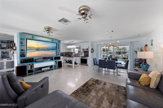 living room featuring ceiling fan with notable chandelier