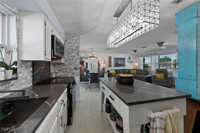 kitchen featuring sink, black / electric stove, tasteful backsplash, white cabinets, and ceiling fan