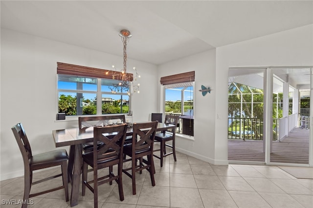 dining space with light tile patterned floors and a notable chandelier