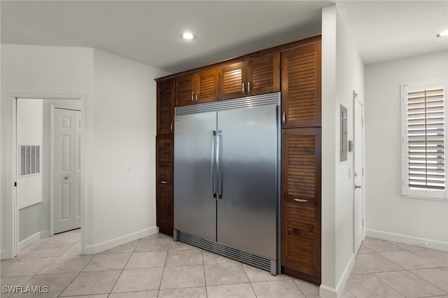 kitchen featuring stainless steel built in refrigerator and light tile patterned floors