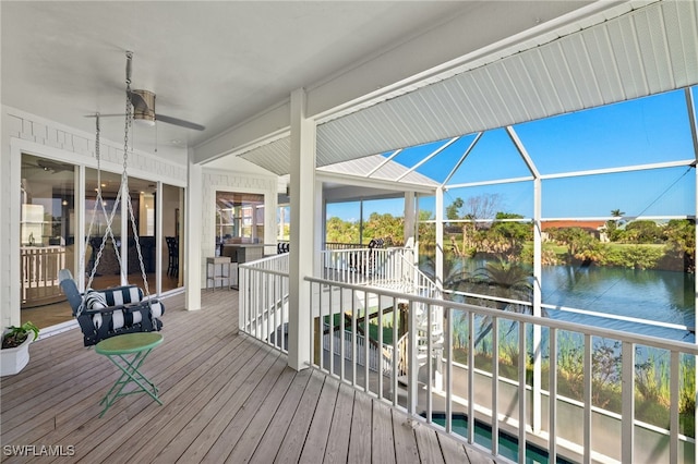 wooden deck with a water view and ceiling fan