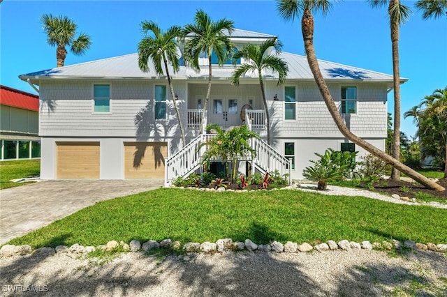 view of front of property featuring a porch, a garage, and a front yard