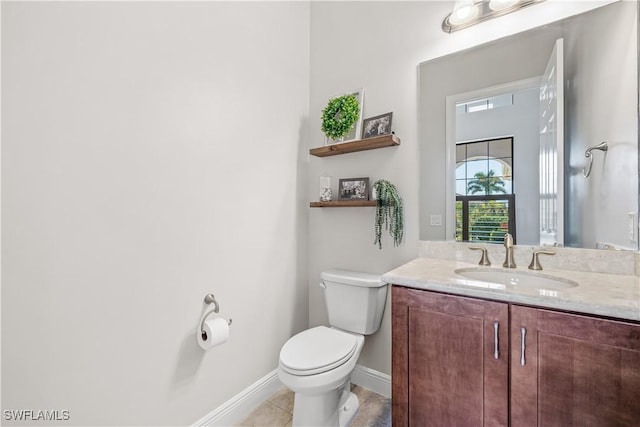 bathroom with tile patterned flooring, vanity, and toilet