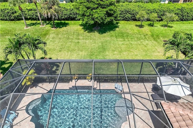 view of pool with a patio, a lanai, pool water feature, and a lawn