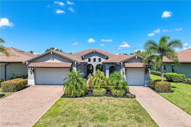 mediterranean / spanish-style house featuring a garage and a front yard