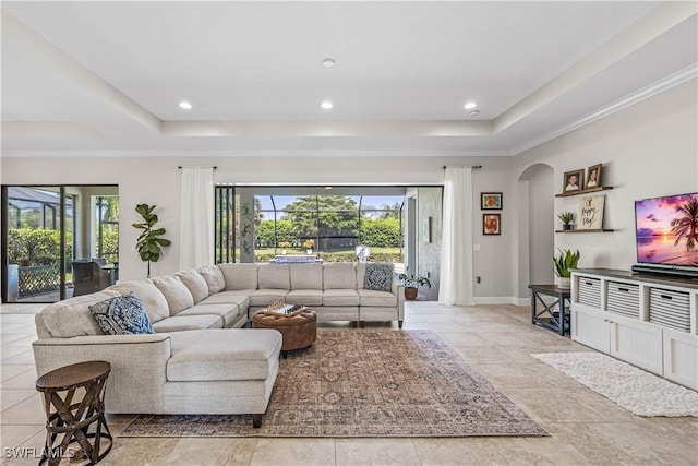 living room with ornamental molding and a tray ceiling