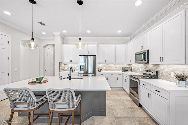 kitchen with stainless steel appliances, decorative light fixtures, sink, and white cabinets