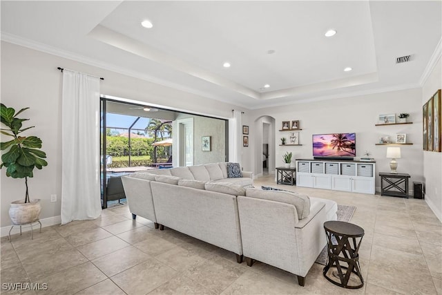 living room with ornamental molding and a tray ceiling