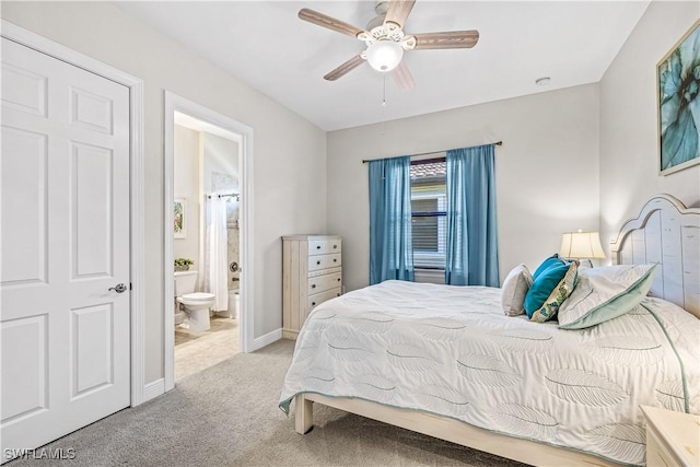 bedroom with ensuite bathroom, light carpet, and ceiling fan