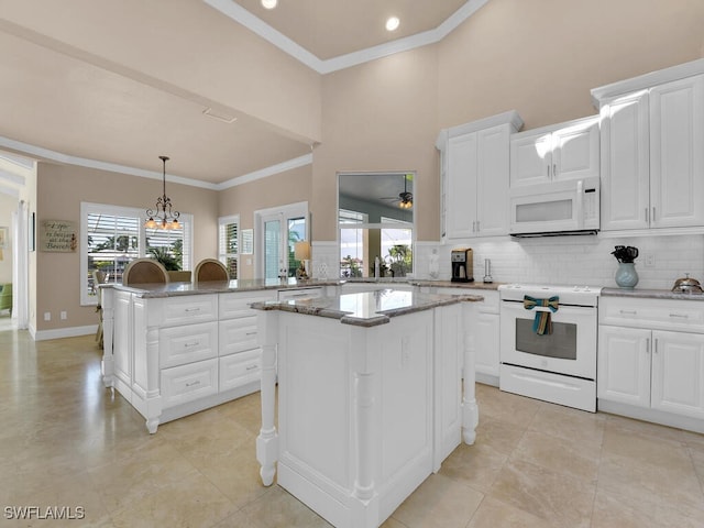 kitchen featuring a kitchen island, white appliances, and a healthy amount of sunlight