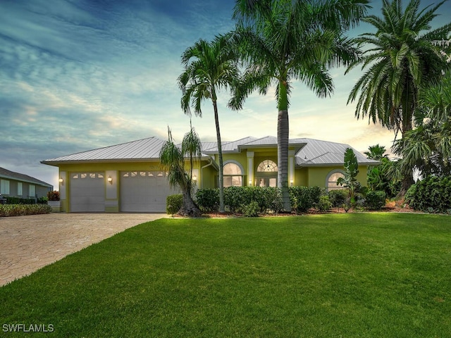 ranch-style house with a yard and a garage