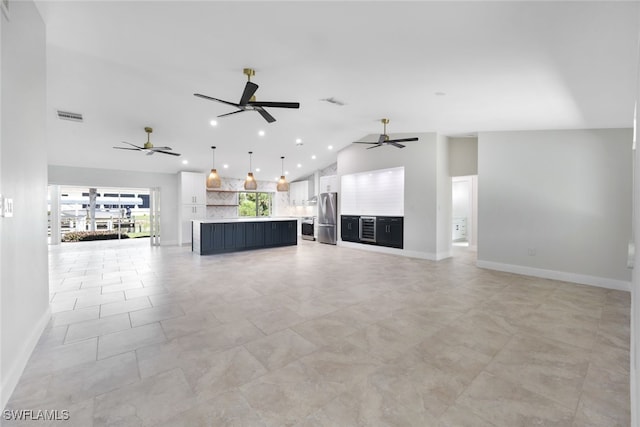 unfurnished living room featuring ceiling fan and high vaulted ceiling