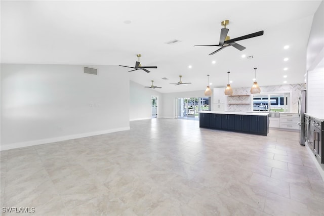 unfurnished living room featuring ceiling fan and vaulted ceiling