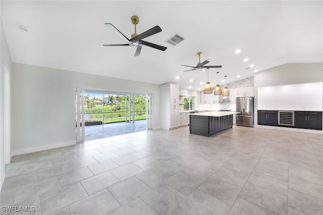 unfurnished living room featuring ceiling fan, lofted ceiling, and light tile patterned floors