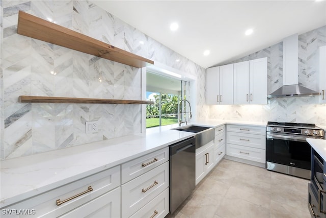 kitchen with white cabinets, appliances with stainless steel finishes, sink, and light stone countertops