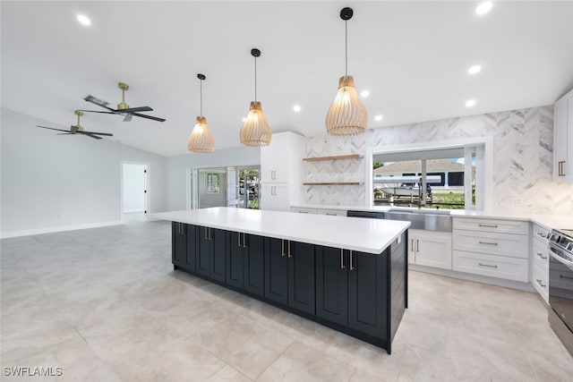 kitchen with ceiling fan, white cabinets, sink, and a center island