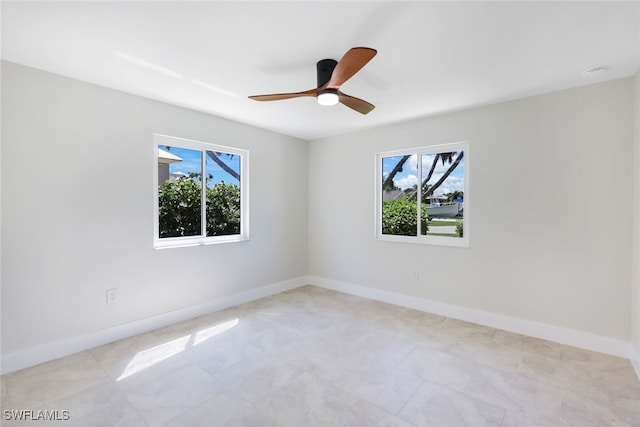 spare room featuring ceiling fan and a wealth of natural light