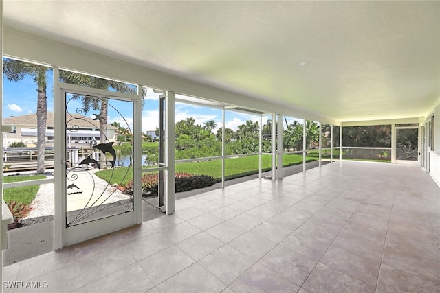 unfurnished sunroom featuring a water view