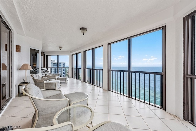 sunroom featuring a water view