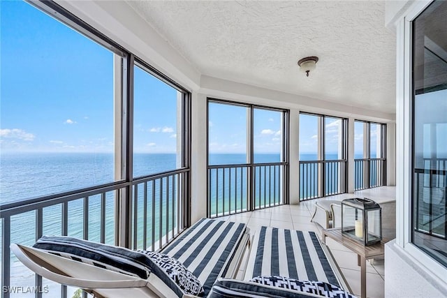 8171 Bay Colony Dr Unit 2004, Naples, FL 34108 - unfurnished sunroom with a water view, tile patterned floors, and a textured ceiling
