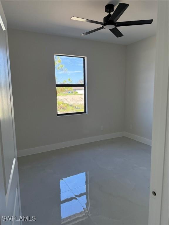 spare room featuring concrete floors and ceiling fan