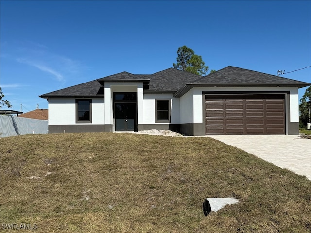 view of front of house featuring a garage and a front lawn