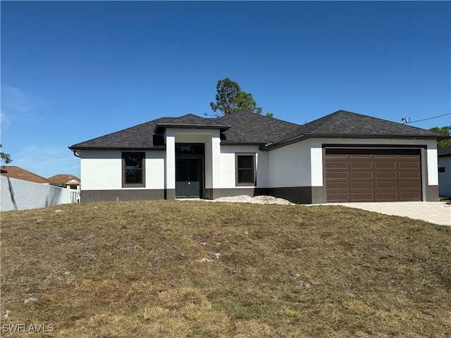 view of front of property featuring a garage and a front lawn