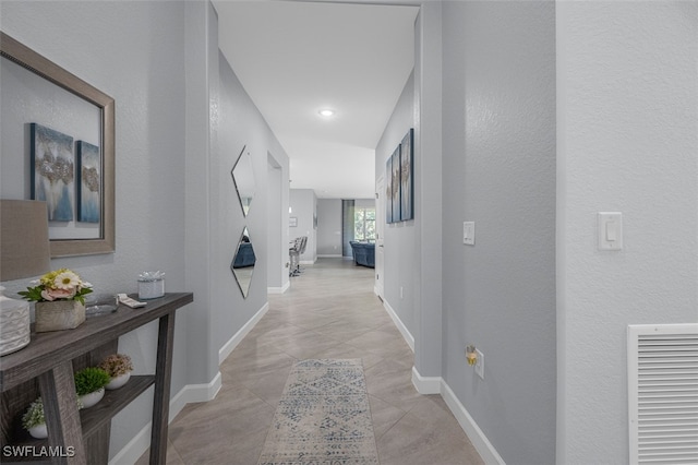 hall featuring light tile patterned floors