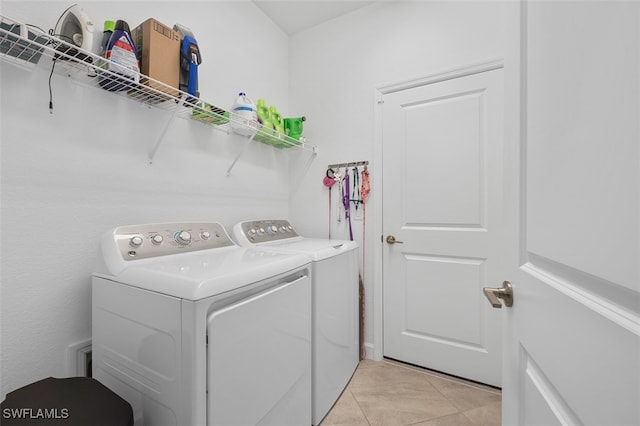 laundry area with light tile patterned floors and washer and dryer