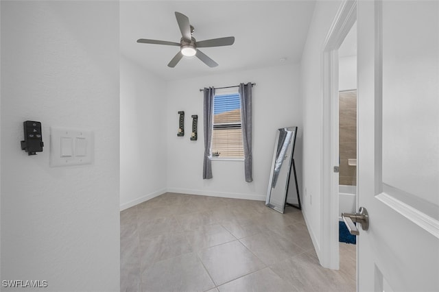 tiled spare room featuring ceiling fan