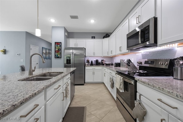 kitchen featuring light stone counters, hanging light fixtures, sink, white cabinetry, and appliances with stainless steel finishes