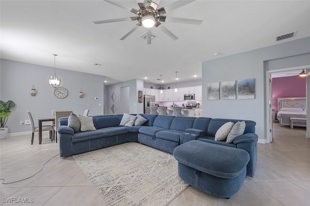 living room with ceiling fan with notable chandelier and light tile patterned flooring