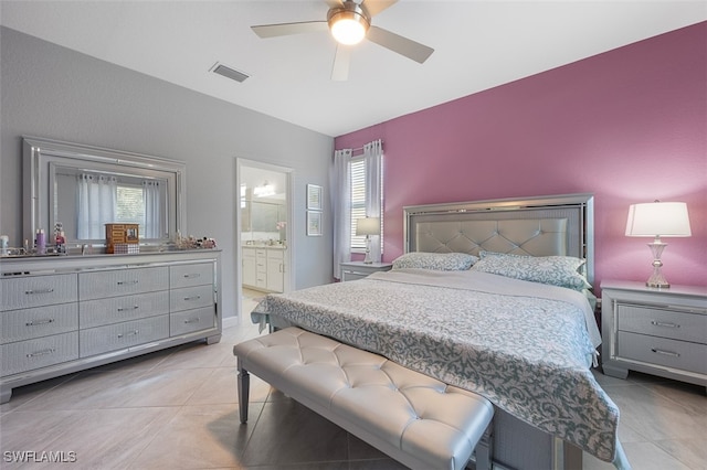 bedroom featuring light tile patterned floors, lofted ceiling, ensuite bath, and ceiling fan