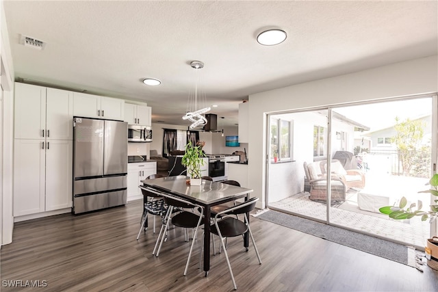 dining room featuring a textured ceiling and dark wood-type flooring