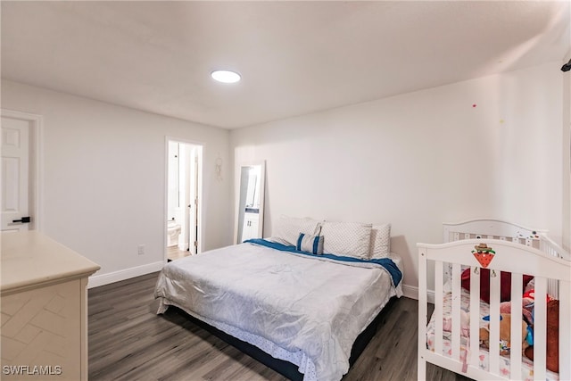 bedroom featuring ensuite bathroom and dark wood-type flooring