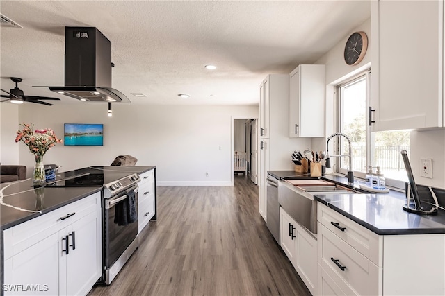 kitchen with white cabinetry, stainless steel appliances, ventilation hood, wood-type flooring, and a textured ceiling