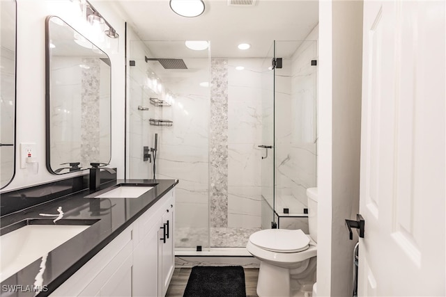 bathroom with walk in shower, vanity, and toilet