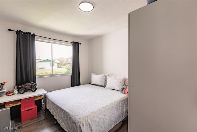 bedroom with a textured ceiling and dark wood-type flooring