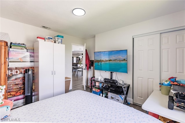 bedroom with dark hardwood / wood-style floors and a closet