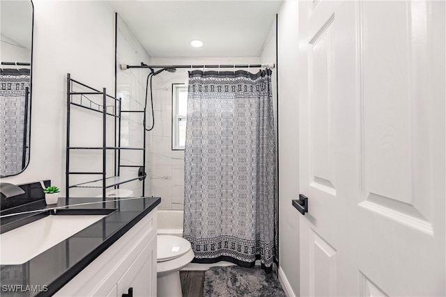 full bathroom featuring shower / bath combination with curtain, vanity, and toilet