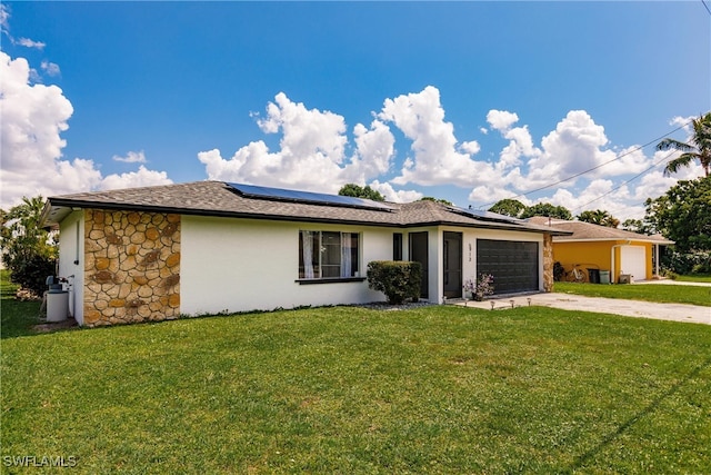 ranch-style house featuring a front yard, solar panels, and a garage