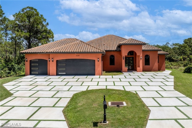 mediterranean / spanish-style house featuring a garage and a front yard