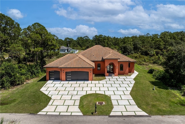 mediterranean / spanish house with a front yard and a garage