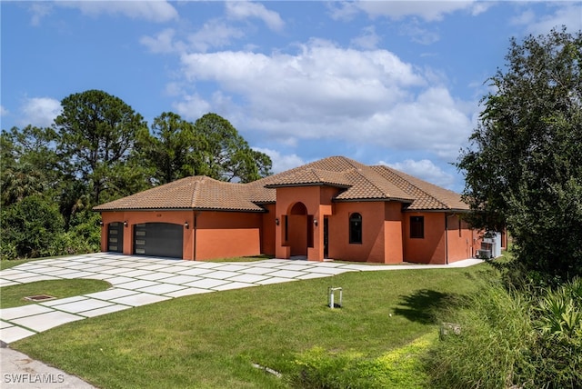 mediterranean / spanish-style house featuring a garage and a front yard