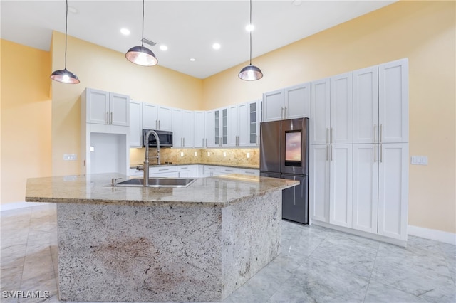 kitchen with appliances with stainless steel finishes, hanging light fixtures, a spacious island, and white cabinets