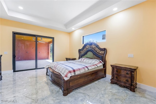 bedroom featuring a tray ceiling and access to outside